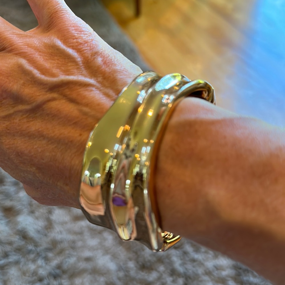 Gold tone chunky bracelet with asymmetrical curve pattern